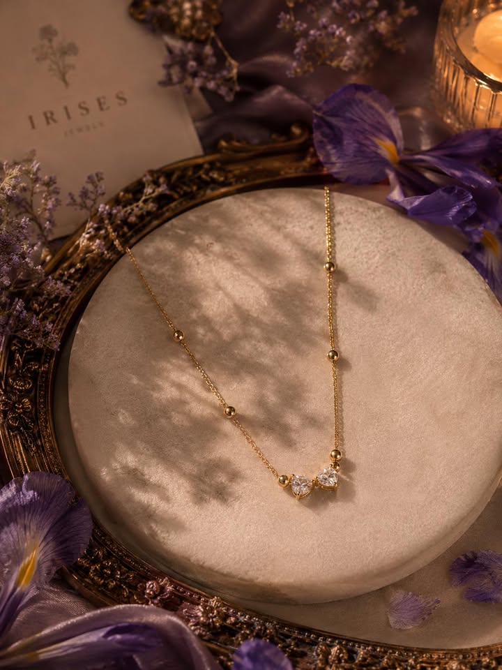 A delicate Celeste Crystal Heart Bead Necklace featuring sparkling heart-shaped crystals and delicate gold-tone bead detailing.